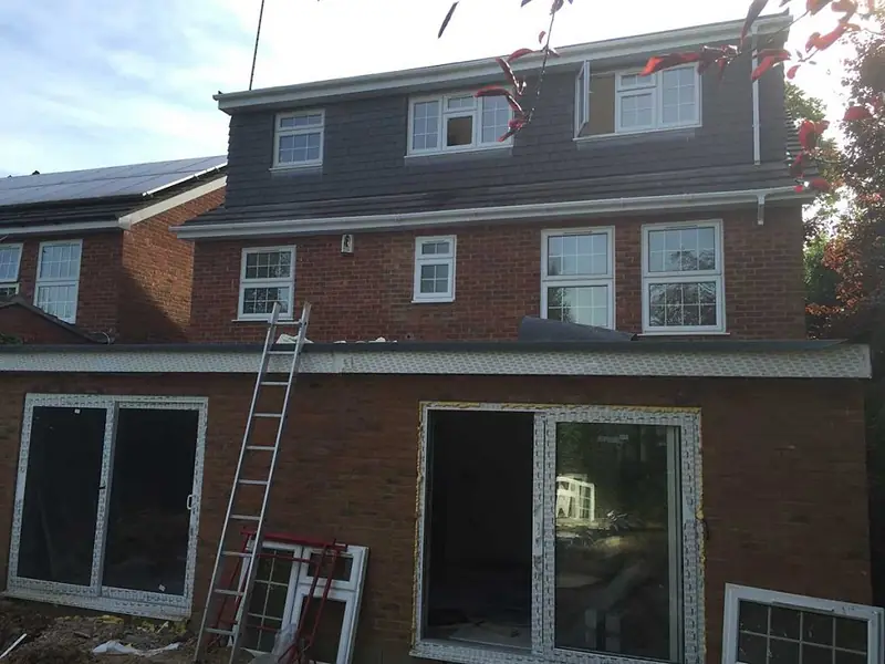 Brick rear extension with large glazed doors, and a new loft dormer above it, on a three-storey house