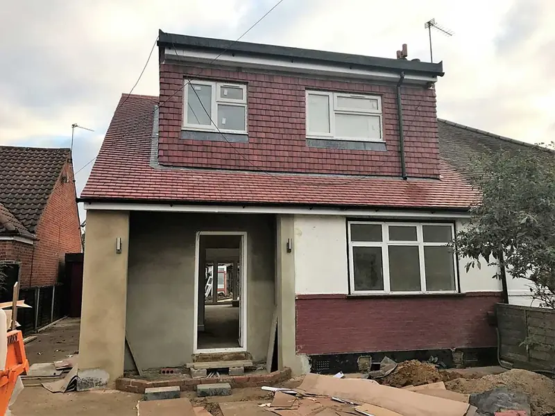 Single-storey rear extension being rendered, with a new tiled dormer on the roof above